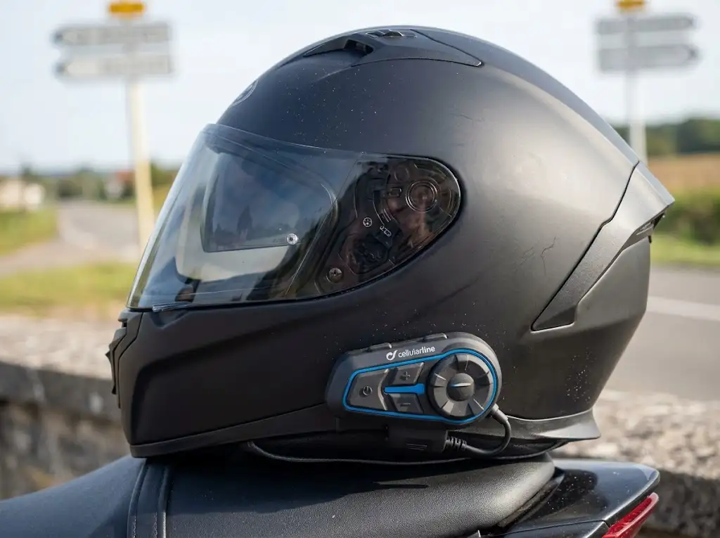 Intercom Cellularline fixé sur le côté d'un casque de moto intégral pour motard en France